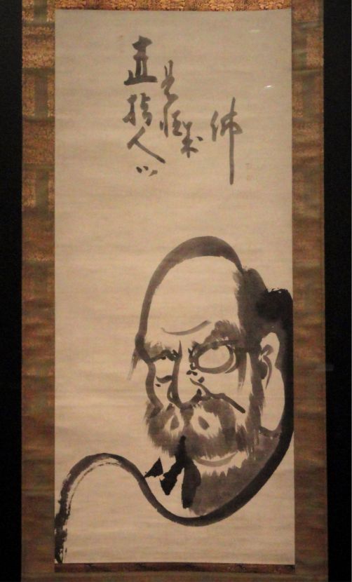 Traditional Japanese ink scroll depicting Bodhidharma (Daruma), the founder of Zen Buddhism, displayed at Upaya Sangha of Tucson.
