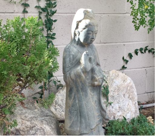 kannon-bodhisattva-statue-upaya-sangha-tucso Stone statue of Kannon (Guanyin), the Bodhisattva of Compassion, in a peaceful meditation garden at Upaya Sangha of Tucson.